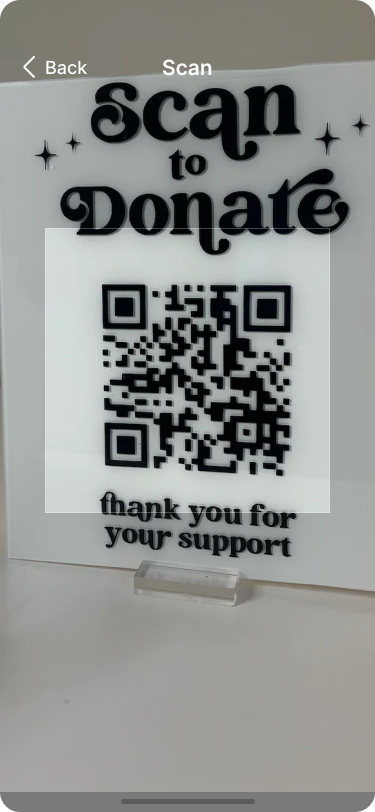 Image of a sign with a QR code that reads ‘Scan to Donate’ at the top and ‘thank you for your support’ at the bottom. The QR code is prominently displayed in the center, inviting users to scan and make a donation.